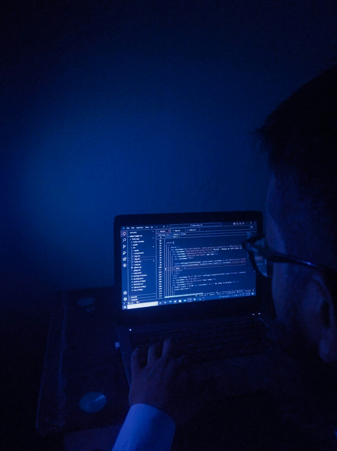 programmer writing code on laptop